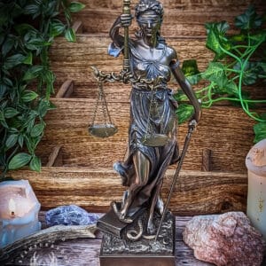 This statue honours La Justicia, or Themis- the Goddess of divine Justice. Impartial due to the blindfold, she stands with the scales of justice and is the holder of true divine law. A Titan Goddess that oversees and organises civility and assemblies, to keep things in their true and proper order. Themis is often worshipped alongside other Gods of Justice, Fate or Civility, such as Artemis, Nemesis and the Fates. When Themis' warnings are ignored, Nemesis is called to bring divine, justice driven revenge. Although the blindfold is of an early-modern cultural symbol attached to Lady Justice, we choose to stock it as it's how living folk magic practitioners now work with her. Themis is also seen as being oracular in her earliest cults, and we feel the blindfold could also tie in nicely with this aspect of her worship too. Once you’ve received the statue- make sure to ‘awaken’ the statue in any way you see fit. This could be through annointing oil, sacred incense blends or through using a light wash. We suggest an offering incense to welcome in the spirit. You can either use this statue symbolically, devotionally or as part of physical spell workings. This statue stands at 33cm, and is made from high quality resin and arrives in it's original box. Because each statue is hand painted, statues may differ slightly in appearance.